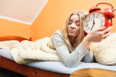 Δυστυχισμένη γυναίκα που ξυπνά με το ξυπνητήρι Στοκ Φωτογραφία Δυστυχισμένη γυναίκα που ξυπνά με το ξυπνητήρι Στοκ Φωτογραφία
