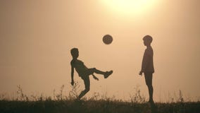 Δύο αγόρια που παίζουν το ποδόσφαιρο στο ηλιοβασίλεμα Σκιαγραφία των παιδιών που παίζουν με μια σφαίρα στο ηλιοβασίλεμα Η έννοια απόθεμα βίντεο Δύο αγόρια που παίζουν το ποδόσφαιρο στο ηλιοβασίλεμα Σκιαγραφία των παιδιών που παίζουν με μια σφαίρα στο ηλιοβασίλεμα Η έννοια απόθεμα βίντεο