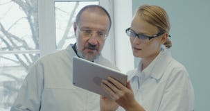 Δύο γιατροί που διοργανώνουν την επαγγελματική συζήτηση που χρησιμοποιεί την αφή απόθεμα βίντεο Δύο γιατροί που διοργανώνουν την επαγγελματική συζήτηση που χρησιμοποιεί την αφή απόθεμα βίντεο