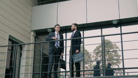 Δύο επιχειρησιακοί συνάδελφοι που χαιρετούν ο ένας τον άλλον στην είσοδο του εμπορικού κέντρου απόθεμα βίντεο Δύο επιχειρησιακοί συνάδελφοι που χαιρετούν ο ένας τον άλλον στην είσοδο του εμπορικού κέντρου απόθεμα βίντεο