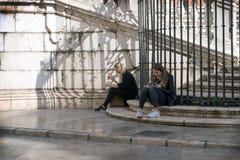 Μάλαγα, Ισπανία, το Φεβρουάριο του 2019 Δύο κορίτσια χαλαρώνουν στα μαρμάρινα βήματα του διάσημου ενσαρκωμένου καθεδρικού ναού Ma στοκ φωτογραφία με δικαίωμα ελεύθερης χρήσης Μάλαγα, Ισπανία, το Φεβρουάριο του 2019 Δύο κορίτσια χαλαρώνουν στα μαρμάρινα βήματα του διάσημου ενσαρκωμένου καθεδρικού ναού Ma στοκ φωτογραφία με δικαίωμα ελεύθερης χρήσης