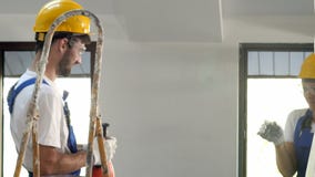 Δύο μηχανικοί hardhats που έχουν τη διασκέδαση εργαζόμενοι στο εργοτάξιο οικοδομής του κτηρίου απόθεμα βίντεο Δύο μηχανικοί hardhats που έχουν τη διασκέδαση εργαζόμενοι στο εργοτάξιο οικοδομής του κτηρίου απόθεμα βίντεο