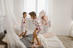Δύο μικρά κορίτσια στις πυτζάμες τους έχουν τη διασκέδαση που πηδά σε στοκ φωτογραφία Δύο μικρά κορίτσια στις πυτζάμες τους έχουν τη διασκέδαση που πηδά σε στοκ φωτογραφία