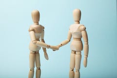 Δύο ξύλινοι αριθμοί του ατόμου τινάζουν τα χέρια στοκ εικόνες Δύο ξύλινοι αριθμοί του ατόμου τινάζουν τα χέρια στοκ εικόνες