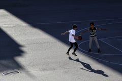 Δύο παιδιά παίζουν την καλαθοσφαίριση σε έναν αθλητικό τομέα οδών στοκ φωτογραφίες Δύο παιδιά παίζουν την καλαθοσφαίριση σε έναν αθλητικό τομέα οδών στοκ φωτογραφίες