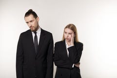 Δύο συνέταιροι στα μαύρα κοστούμια, ο όμορφος γενειοφόρος άνδρας και η όμορφη ξανθή γυναίκα που συγκλονίζονται δεν ξέρουν τι για στοκ φωτογραφίες Δύο συνέταιροι στα μαύρα κοστούμια, ο όμορφος γενειοφόρος άνδρας και η όμορφη ξανθή γυναίκα που συγκλονίζονται δεν ξέρουν τι για στοκ φωτογραφίες