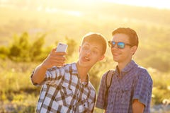 Δύο χαριτωμένοι τύποι παίρνουν selfies τους ευτυχείς φίλους φωτογραφίζονται στο τηλέφωνο στοκ φωτογραφία Δύο χαριτωμένοι τύποι παίρνουν selfies τους ευτυχείς φίλους φωτογραφίζονται στο τηλέφωνο στοκ φωτογραφία
