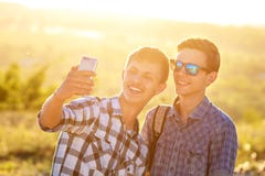 Δύο χαριτωμένοι τύποι παίρνουν selfies τους ευτυχείς φίλους φωτογραφίζονται στο τηλέφωνο στοκ φωτογραφίες Δύο χαριτωμένοι τύποι παίρνουν selfies τους ευτυχείς φίλους φωτογραφίζονται στο τηλέφωνο στοκ φωτογραφίες