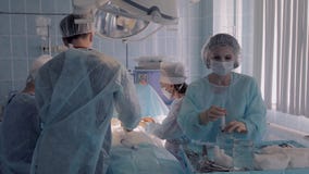 Δύο χειρούργοι που εκτελούν μια λειτουργία μαζί με τις χειρουργικές νοσοκόμες απόθεμα βίντεο Δύο χειρούργοι που εκτελούν μια λειτουργία μαζί με τις χειρουργικές νοσοκόμες απόθεμα βίντεο
