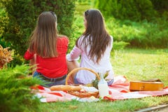 Δύο όμορφα νέα κορίτσια σε ένα πικ-νίκ το καλοκαίρι στο πάρκο που διοργανώνει τη διασκέδαση και την ομιλία Στοκ εικόνες με δικαίωμα ελεύθερης χρήσης Δύο όμορφα νέα κορίτσια σε ένα πικ-νίκ το καλοκαίρι στο πάρκο που διοργανώνει τη διασκέδαση και την ομιλία Στοκ εικόνες με δικαίωμα ελεύθερης χρήσης