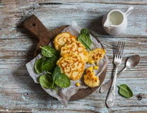 Ελεύθερα fritters καλαμποκιού γλουτένης και φρέσκο σπανάκι σε έναν ξύλινο πίνακα στοκ εικόνες Ελεύθερα fritters καλαμποκιού γλουτένης και φρέσκο σπανάκι σε έναν ξύλινο πίνακα στοκ εικόνες