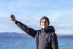 Εικόνα ενός νεαρού άνδρα που παίρνει ένα selfie με το τηλέφωνό του στοκ εικόνες με δικαίωμα ελεύθερης χρήσης Εικόνα ενός νεαρού άνδρα που παίρνει ένα selfie με το τηλέφωνό του στοκ εικόνες με δικαίωμα ελεύθερης χρήσης