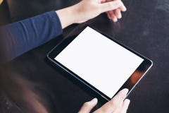 Εικόνα προτύπων των χεριών που χρησιμοποιούν ένα μαύρο PC ταμπλετών με την κενή άσπρη οθόνη στον εκλεκτής ποιότητας μαύρο πίνακα στοκ εικόνες Εικόνα προτύπων των χεριών που χρησιμοποιούν ένα μαύρο PC ταμπλετών με την κενή άσπρη οθόνη στον εκλεκτής ποιότητας μαύρο πίνακα στοκ εικόνες