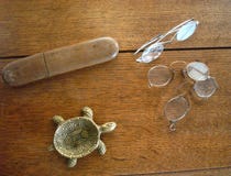Εκλεκτής ποιότητας ashtray χελωνών, γυαλιά, και κιβώτιο γυαλιών σε μια ξύλινη επιφάνεια στοκ φωτογραφία Εκλεκτής ποιότητας ashtray χελωνών, γυαλιά, και κιβώτιο γυαλιών σε μια ξύλινη επιφάνεια στοκ φωτογραφία