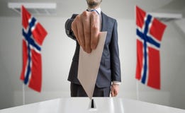 Εκλογή ή δημοψήφισμα στη Νορβηγία Ο ψηφοφόρος κρατά το φάκελο διαθέσιμο επάνω από την ψήφο Νορβηγικές σημαίες στο υπόβαθρο στοκ φωτογραφίες Εκλογή ή δημοψήφισμα στη Νορβηγία Ο ψηφοφόρος κρατά το φάκελο διαθέσιμο επάνω από την ψήφο Νορβηγικές σημαίες στο υπόβαθρο στοκ φωτογραφίες