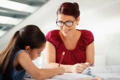 Εκπαίδευση με Mom που βοηθά την κόρη που κάνει τη σχολική εργασία στο σπίτι Στοκ Φωτογραφία Εκπαίδευση με Mom που βοηθά την κόρη που κάνει τη σχολική εργασία στο σπίτι Στοκ Φωτογραφία