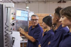 Εκπαιδευτικοί μαθητευόμενοι μηχανικών CNC στη μηχανή στοκ εικόνες Εκπαιδευτικοί μαθητευόμενοι μηχανικών CNC στη μηχανή στοκ εικόνες