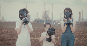 Εκτός από τις εγκαταστάσεις Παιδιά που φορούν τις μάσκες αερίου κοντά σε ένα μεγάλο διυλιστήριο πετρελαίου απόθεμα βίντεο Εκτός από τις εγκαταστάσεις Παιδιά που φορούν τις μάσκες αερίου κοντά σε ένα μεγάλο διυλιστήριο πετρελαίου απόθεμα βίντεο
