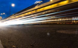 Ελαφριά ίχνη αυτοκινήτων στην οδό κοντά στην οδική γέφυρα, άνθρωποι που περπατούν στη γρήγορη κίνηση, υπόβαθρο οδών νύχτας στοκ εικόνα με δικαίωμα ελεύθερης χρήσης Ελαφριά ίχνη αυτοκινήτων στην οδό κοντά στην οδική γέφυρα, άνθρωποι που περπατούν στη γρήγορη κίνηση, υπόβαθρο οδών νύχτας στοκ εικόνα με δικαίωμα ελεύθερης χρήσης