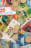 Ελβετικά χρήματα φράγκων στα νομίσματα και τους ζωηρόχρωμους λογαριασμούς στοκ εικόνες Ελβετικά χρήματα φράγκων στα νομίσματα και τους ζωηρόχρωμους λογαριασμούς στοκ εικόνες