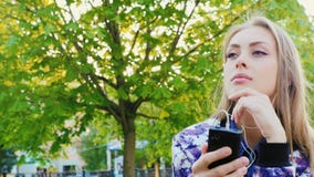 Ελκυστική γυναίκα που ακούει τη μουσική στο πάρκο Αυτή ακουστικά, άνοιξη υπαίθρια απόθεμα βίντεο Ελκυστική γυναίκα που ακούει τη μουσική στο πάρκο Αυτή ακουστικά, άνοιξη υπαίθρια απόθεμα βίντεο