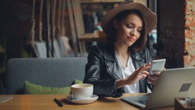 Ελκυστική νέα γυναίκα που χρησιμοποιεί το smartphone στον καφέ που απολαμβάνει το κοινωνικό χαμόγελο μέσων απόθεμα βίντεο Ελκυστική νέα γυναίκα που χρησιμοποιεί το smartphone στον καφέ που απολαμβάνει το κοινωνικό χαμόγελο μέσων απόθεμα βίντεο