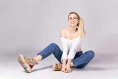 Ελκυστική νέα τοποθέτηση γυναικών πέρα από το γκρίζο υπόβαθρο στοκ φωτογραφία Ελκυστική νέα τοποθέτηση γυναικών πέρα από το γκρίζο υπόβαθρο στοκ φωτογραφία