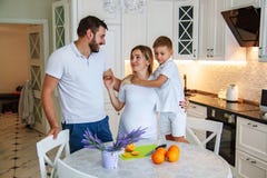 Ελκυστικό ζεύγος με τη έγκυο γυναίκα που έχει το πρόγευμα στην κουζίνα μαζί με το παιδί στοκ φωτογραφία με δικαίωμα ελεύθερης χρήσης Ελκυστικό ζεύγος με τη έγκυο γυναίκα που έχει το πρόγευμα στην κουζίνα μαζί με το παιδί στοκ φωτογραφία με δικαίωμα ελεύθερης χρήσης