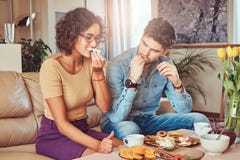 Ελκυστικό ζεύγος, όμορφος γενειοφόρος μοντέρνος τύπος και σγουρό κορίτσι ομορφιάς που τρώνε ένα γεύμα στο σπίτι στοκ εικόνες Ελκυστικό ζεύγος, όμορφος γενειοφόρος μοντέρνος τύπος και σγουρό κορίτσι ομορφιάς που τρώνε ένα γεύμα στο σπίτι στοκ εικόνες
