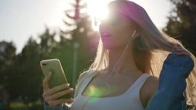 Ελκυστικός ξανθός πνίγει τη μουσική στο smartphone της υπαίθρια Γυναίκα που απολαμβάνει τη μουσική στο ηλιοβασίλεμα o φιλμ μικρού μήκους Ελκυστικός ξανθός πνίγει τη μουσική στο smartphone της υπαίθρια Γυναίκα που απολαμβάνει τη μουσική στο ηλιοβασίλεμα o φιλμ μικρού μήκους