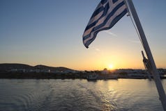 Ελλάδα, Paros, ελληνική σημαία στο ηλιοβασίλεμα στο πορθμείο στοκ φωτογραφία με δικαίωμα ελεύθερης χρήσης Ελλάδα, Paros, ελληνική σημαία στο ηλιοβασίλεμα στο πορθμείο στοκ φωτογραφία με δικαίωμα ελεύθερης χρήσης
