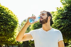 Ενήλικο πόσιμο νερό ατόμων από ένα μπουκάλι έξω στοκ φωτογραφίες Ενήλικο πόσιμο νερό ατόμων από ένα μπουκάλι έξω στοκ φωτογραφίες