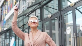 Ενήλικη επιχειρησιακή γυναίκα με το PC ταμπλετών με την περιοχή γραφείων στο υπόβαθρο απόθεμα βίντεο Ενήλικη επιχειρησιακή γυναίκα με το PC ταμπλετών με την περιοχή γραφείων στο υπόβαθρο απόθεμα βίντεο