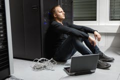 Εξαντλημένος μέσος ενήλικος αρσενικός τεχνικός ενάντια στο ράφι κεντρικών υπολογιστών σε Datacenter στοκ εικόνα με δικαίωμα ελεύθερης χρήσης Εξαντλημένος μέσος ενήλικος αρσενικός τεχνικός ενάντια στο ράφι κεντρικών υπολογιστών σε Datacenter στοκ εικόνα με δικαίωμα ελεύθερης χρήσης