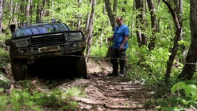Εξερευνητικό SUV που αποκτάται κολλημένο στο δάσος και προσπάθεια να βγεί μέσω του βαρούλκου απόθεμα βίντεο Εξερευνητικό SUV που αποκτάται κολλημένο στο δάσος και προσπάθεια να βγεί μέσω του βαρούλκου απόθεμα βίντεο