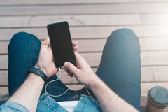 επάνω από την όψη Κινηματογράφηση σε πρώτο πλάνο του smartphone με την κενή οθόνη στα χέρια της συνεδρίασης ατόμων hipster στον π στοκ εικόνες με δικαίωμα ελεύθερης χρήσης επάνω από την όψη Κινηματογράφηση σε πρώτο πλάνο του smartphone με την κενή οθόνη στα χέρια της συνεδρίασης ατόμων hipster στον π στοκ εικόνες με δικαίωμα ελεύθερης χρήσης