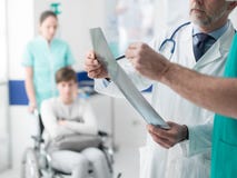 Επαγγελματικοί γιατροί που εξετάζουν την υπομονετική ακτίνα X ` s στοκ εικόνες Επαγγελματικοί γιατροί που εξετάζουν την υπομονετική ακτίνα X ` s στοκ εικόνες