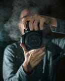 Επαγγελματικός φωτογράφος με μια κάμερα Μαύρη ανασκόπηση στοκ φωτογραφίες με δικαίωμα ελεύθερης χρήσης Επαγγελματικός φωτογράφος με μια κάμερα Μαύρη ανασκόπηση στοκ φωτογραφίες με δικαίωμα ελεύθερης χρήσης