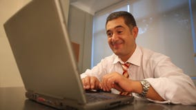 Επιτυχής επιχειρηματίας που χρησιμοποιεί το lap-top στην αρχή απόθεμα βίντεο Επιτυχής επιχειρηματίας που χρησιμοποιεί το lap-top στην αρχή απόθεμα βίντεο