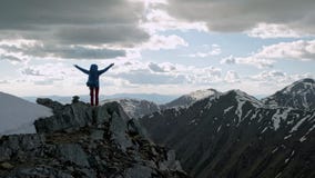Επιτυχείς νέες ανοικτές αγκάλες γυναικών backpacker στην αιχμή βουνών απόθεμα βίντεο Επιτυχείς νέες ανοικτές αγκάλες γυναικών backpacker στην αιχμή βουνών απόθεμα βίντεο