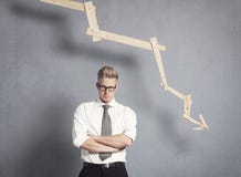 Επιχειρηματίας Displeased μπροστά από τη γραφική παράσταση με την αρνητική τάση. στοκ φωτογραφία Επιχειρηματίας Displeased μπροστά από τη γραφική παράσταση με την αρνητική τάση. στοκ φωτογραφία