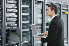 Επιχειρηματίας με το lap-top στο δωμάτιο κεντρικών υπολογιστών δικτύων στοκ φωτογραφία με δικαίωμα ελεύθερης χρήσης Επιχειρηματίας με το lap-top στο δωμάτιο κεντρικών υπολογιστών δικτύων στοκ φωτογραφία με δικαίωμα ελεύθερης χρήσης