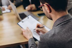 Επιχειρηματίας που εργάζεται με τα έγγραφα στο σύγχρονο γραφείο Πίσω άποψη στοκ εικόνα με δικαίωμα ελεύθερης χρήσης Επιχειρηματίας που εργάζεται με τα έγγραφα στο σύγχρονο γραφείο Πίσω άποψη στοκ εικόνα με δικαίωμα ελεύθερης χρήσης