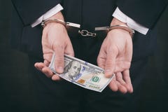 Επιχειρηματίας στις χειροπέδες που κρατά τη δωροδοκία εκατό δολάρια στοκ εικόνες Επιχειρηματίας στις χειροπέδες που κρατά τη δωροδοκία εκατό δολάρια στοκ εικόνες