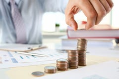 Επιχειρηματίας χεριών που βάζει τα χρήματα καρφιτσών στοκ εικόνες Επιχειρηματίας χεριών που βάζει τα χρήματα καρφιτσών στοκ εικόνες
