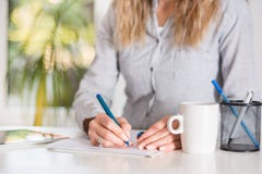 Επιχειρησιακή γυναίκα που γράφει στο έγγραφο με τη μάνδρα στο γραφείο στο σύγχρονο γραφείο στοκ φωτογραφία Επιχειρησιακή γυναίκα που γράφει στο έγγραφο με τη μάνδρα στο γραφείο στο σύγχρονο γραφείο στοκ φωτογραφία