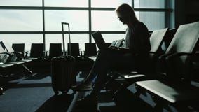 Επιχειρησιακή γυναίκα που εργάζεται με το lap-top στο τερματικό αερολιμένων Αναμονή την πτήση μου Σκιαγραφία στα πλαίσια του α απόθεμα βίντεο Επιχειρησιακή γυναίκα που εργάζεται με το lap-top στο τερματικό αερολιμένων Αναμονή την πτήση μου Σκιαγραφία στα πλαίσια του α απόθεμα βίντεο