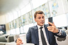 Επιχειρησιακό πρόσωπο που εξετάζει την οθόνη smartphone με την έκπληξη στοκ φωτογραφία με δικαίωμα ελεύθερης χρήσης Επιχειρησιακό πρόσωπο που εξετάζει την οθόνη smartphone με την έκπληξη στοκ φωτογραφία με δικαίωμα ελεύθερης χρήσης
