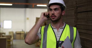 Εργαζόμενος αποθηκών εμπορευμάτων που μιλά στην περιοχή αποκομμάτων τηλεφωνικής εκμετάλλευσης απόθεμα βίντεο Εργαζόμενος αποθηκών εμπορευμάτων που μιλά στην περιοχή αποκομμάτων τηλεφωνικής εκμετάλλευσης απόθεμα βίντεο