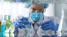 Εργαζόμενος εργαστηρίων που εξετάζει το σωλήνα δοκιμής με το υγρό πρίν αναμιγνύει τα αντιδραστήρια, οικοτροφείο στοκ φωτογραφίες με δικαίωμα ελεύθερης χρήσης Εργαζόμενος εργαστηρίων που εξετάζει το σωλήνα δοκιμής με το υγρό πρίν αναμιγνύει τα αντιδραστήρια, οικοτροφείο στοκ φωτογραφίες με δικαίωμα ελεύθερης χρήσης